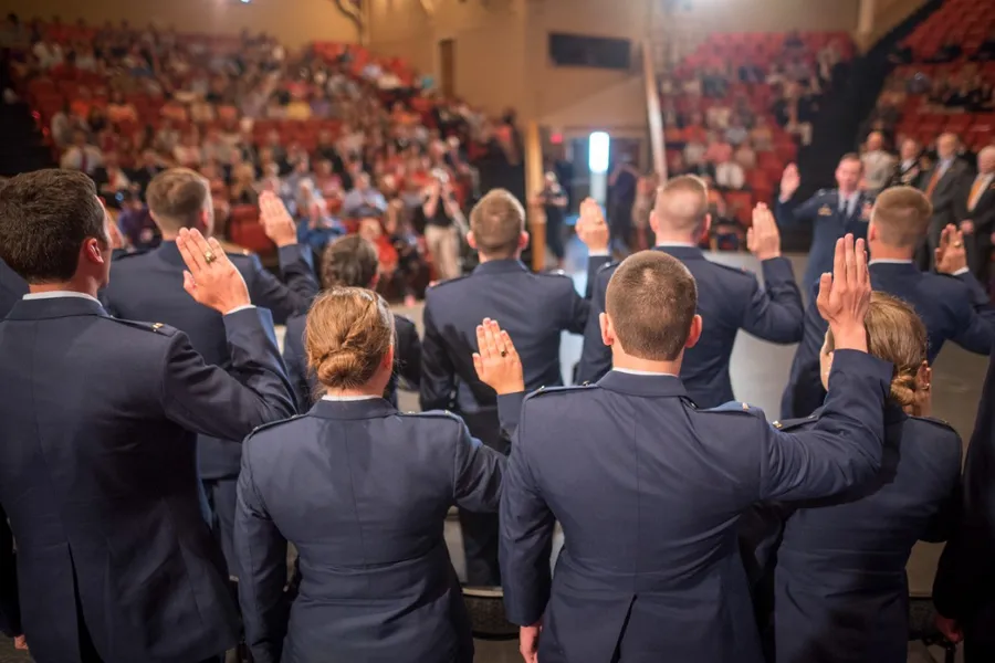 Air Force ROTC cadets raising their right hands to take the oath of office at a commissioning ceremony