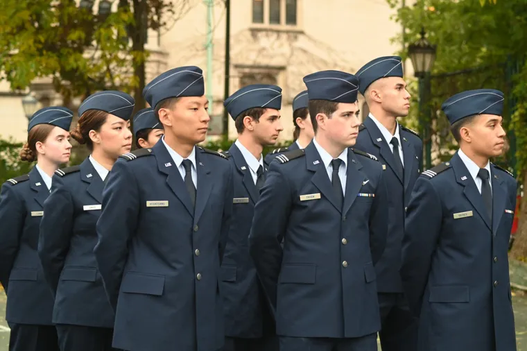 Air Force ROTC cadets standing in formation in service dress uniforms on campus.