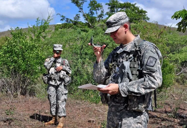 Army ROTC cadet sighting an azimuth through a lensatic compass during land navigation training