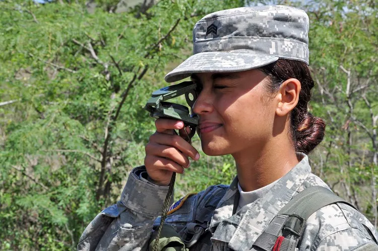 Army ROTC cadet sighting a lensatic compass during land navigation training